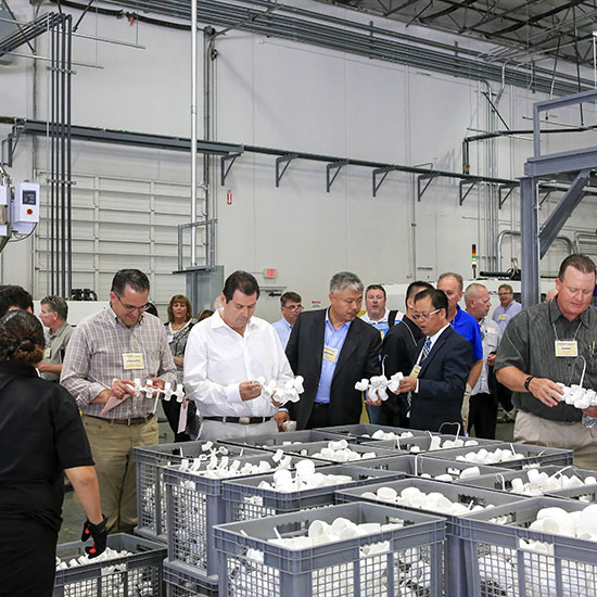 Attendees Checking Out the PVC Pipe Manufacturing Process at Lesso Grand Opening in Corona, California