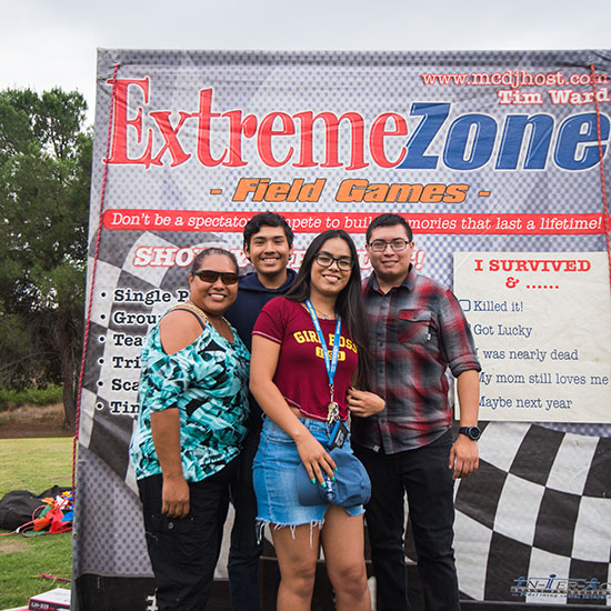 Group Gathered with Winner's Medals In Front of Field Game Sign at AltaMed's Olympic Picnic in Los Angeles