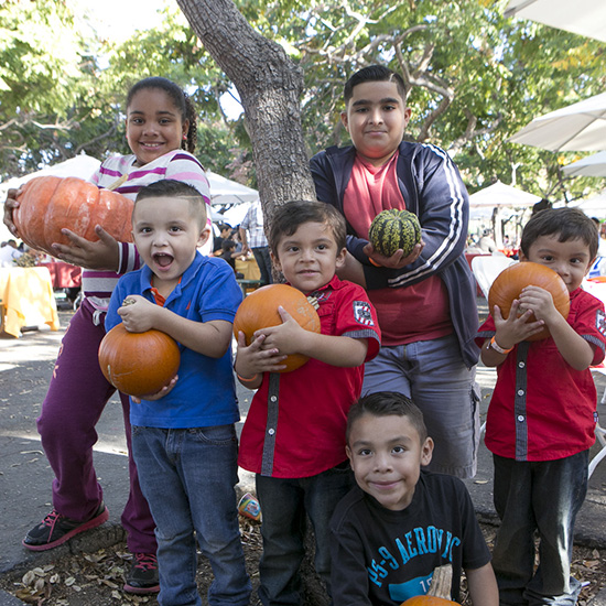 Kids Posing with Pumpkins at Altamed's Halloween Picnic in Los Angeles