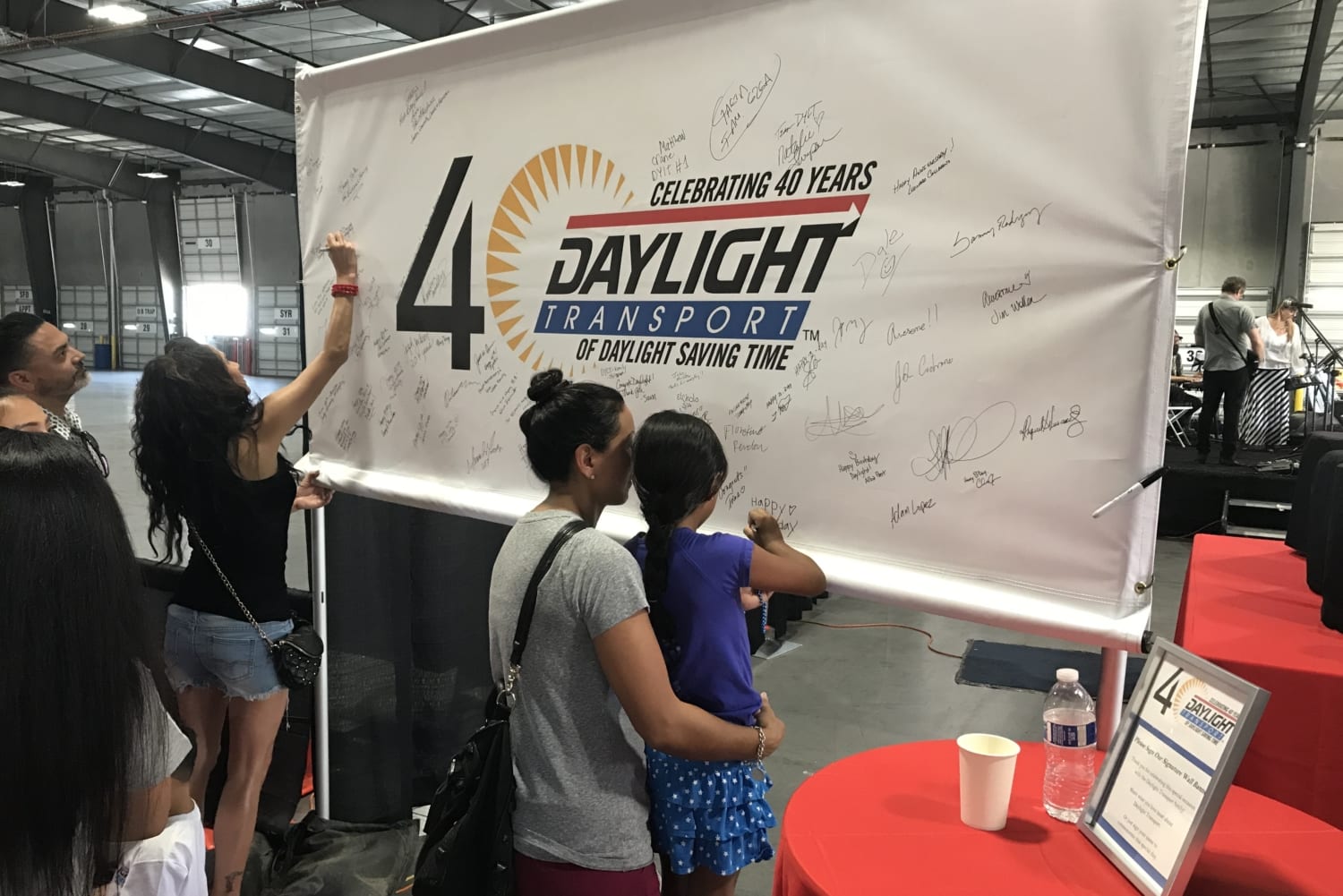 Employees and Guests Signing Banner at Daylight 40th Anniversary Family Friendly Event