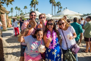 Guests at Company Luau at the Beach for Edwards Lifesciences with Branded Coconuts, Leis and Games Guests at Company Luau at the Beach for Edwards Lifesciences with Branded Coconuts, Leis and Games