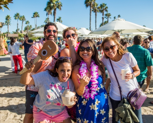 Guests at Company Luau at the Beach for Edwards Lifesciences with Branded Coconuts, Leis and Games Guests at Company Luau at the Beach for Edwards Lifesciences with Branded Coconuts, Leis and Games