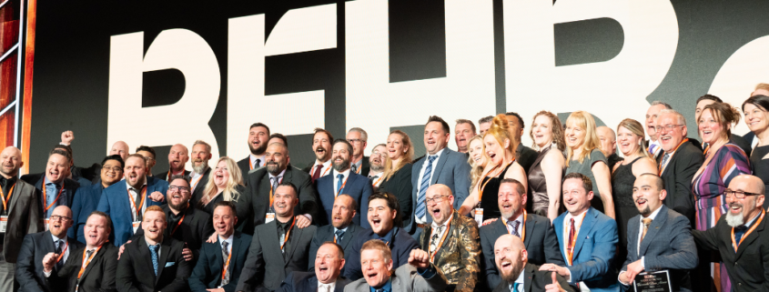 Sales Team Posing with BEHR Logo at International Sales Meeting