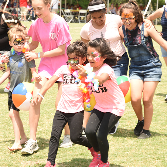 Kids Playing Relay Races at Luau Themed Picnic Company Outing at the Park in Dallas for TBK Bank