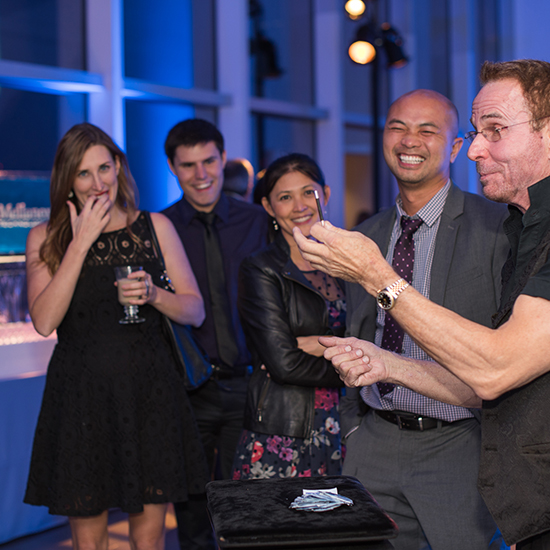 Attendees in formal attire toasting with drinks.
