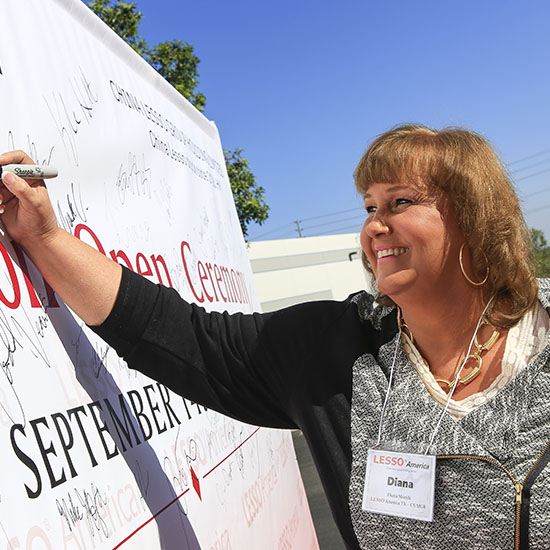 Employee Signing Branded Signature Wall During Lesso Grand Opening in Corona, California