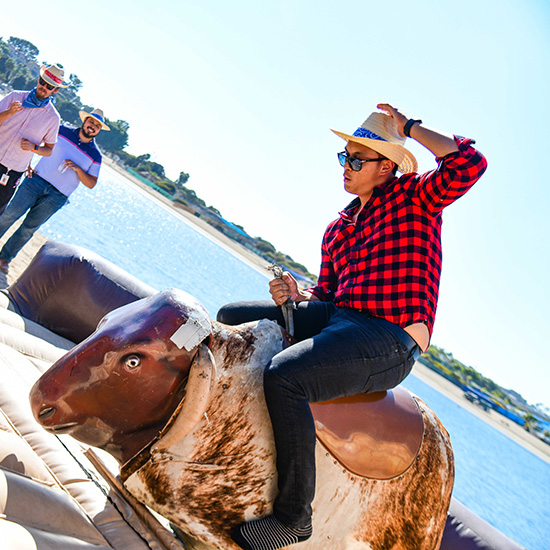 Happy Guests Riding Bull at Wild West Company Picnic at the Beach Newport Dunes CA for EDLS